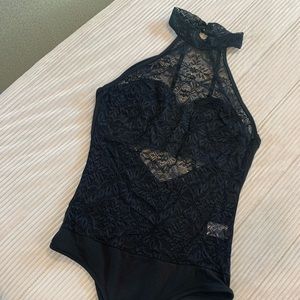 Foreground all lace body suit with open back.